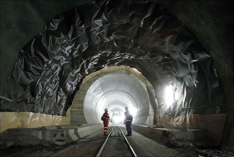 Новый туннель, который в Швейцарии официально считают пока главным проектом наступившего века, позволит поездам преодолевать перевал Сен-Готард на высокой скорости под горным массивом. Сейчас этот маршрут проходит по горам, составы поднимаются на перевале на 1150-метровую высоту. На фото: строители ведут работы по электромонтажу в строящемся туннеле на участке Erstfeld-Amsteg 5 октября. (REUTERS/Arnd Wiegmann)